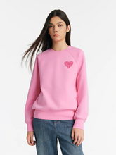 a lady in a pink heart-shaped embroidered pullover sweatshirt